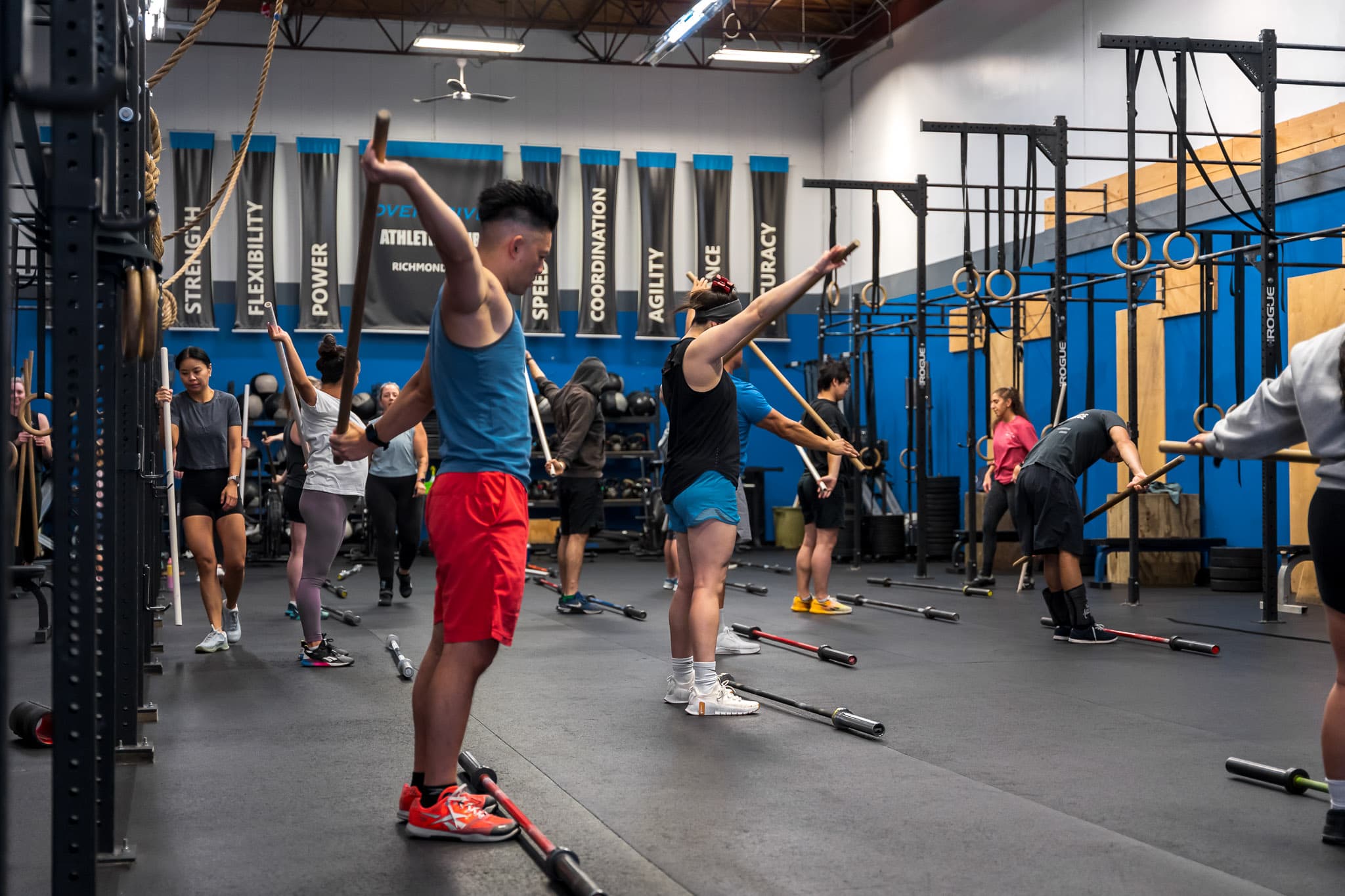 A class working through overhead technique drills with training bars at Overdrive Athletic Club in Richmond, BC