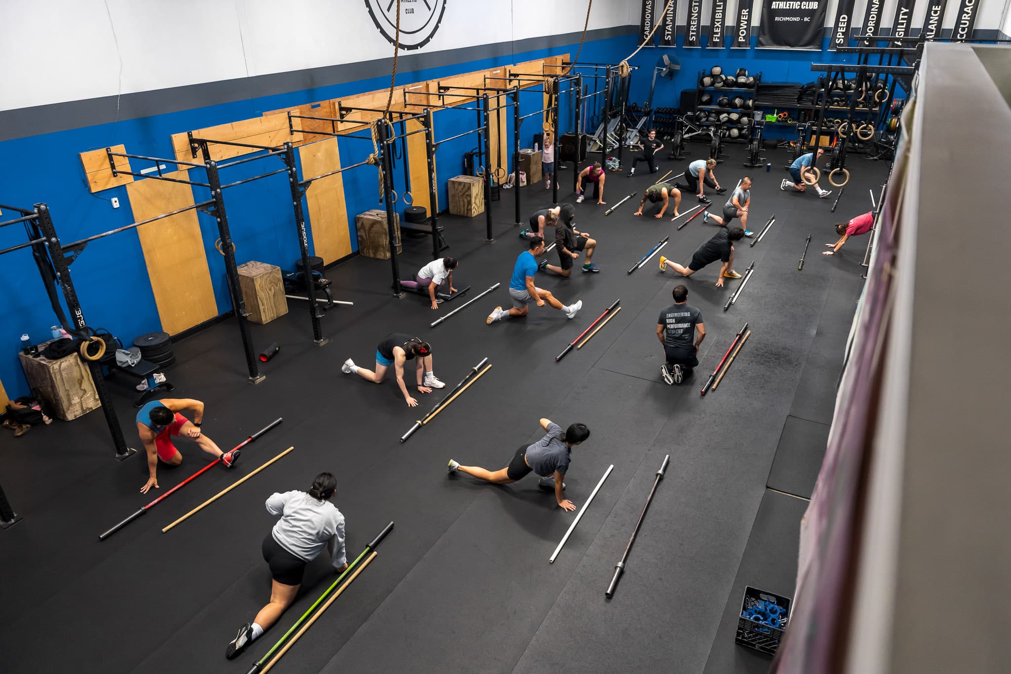 A class warming up with barbells laid out across the floor at Overdrive Athletic Club in Richmond, BC